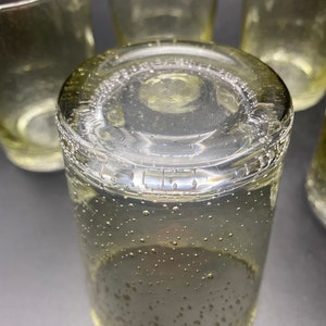 Puede incluir: Un juego de cuatro vasos transparentes de vidrio con una superficie texturizada y burbujeante. Los vasos est&aacute;n apilados uno encima del otro.