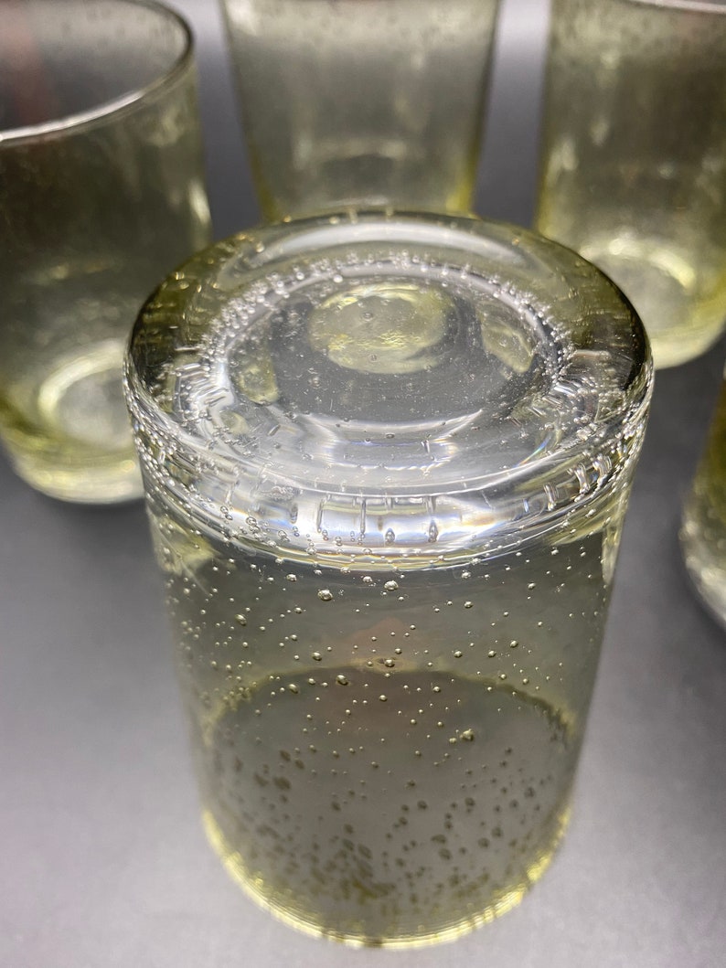 Puede incluir: Un juego de cuatro vasos transparentes de vidrio con una superficie texturizada y burbujeante. Los vasos est&aacute;n apilados uno encima del otro.