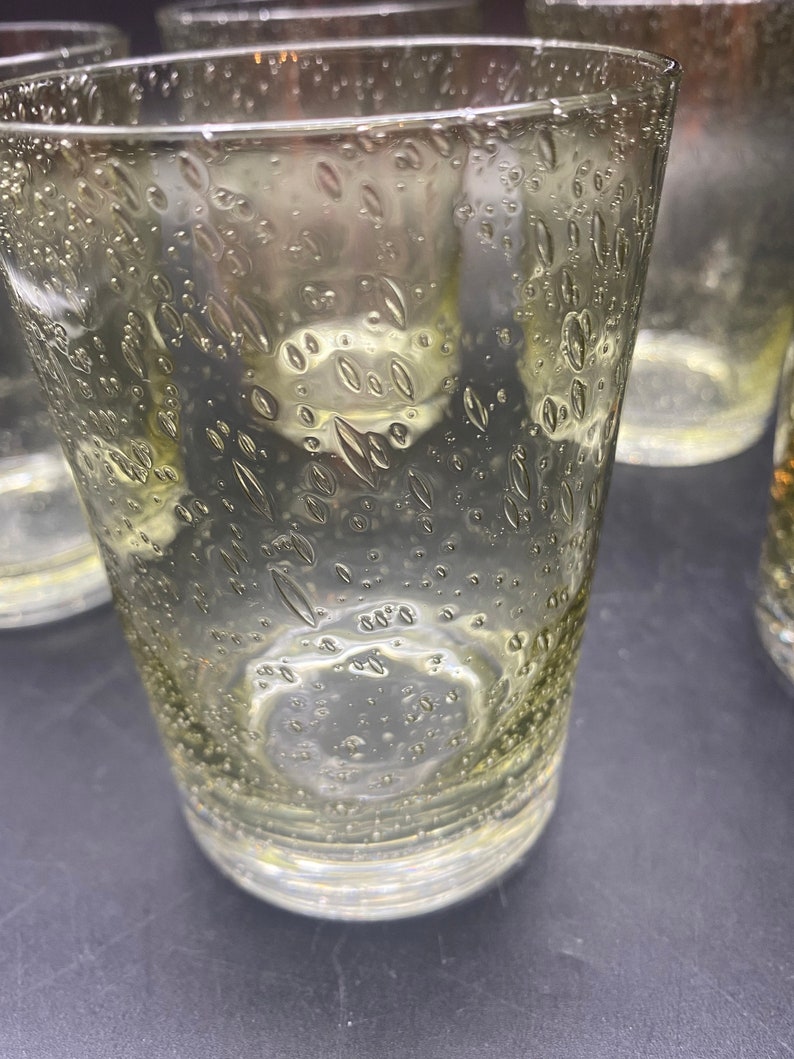Puede incluir: Juego de cuatro vasos transparentes de vidrio con un dise&ntilde;o texturizado de burbujas. Los vasos tienen un tono ligeramente amarillento.