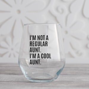 May include: A clear glass wine glass with the text "I'm not a regular aunt. I'm a cool aunt." printed on the side.