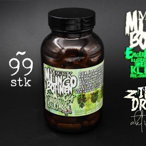 Könnte beinhalten: Eine braune Flasche mit schwarzem Deckel, gefüllt mit braunen Kapseln. Das Etikett lautet "MAGICK MLINGO BOHNEN" mit zusätzlichem Text. Die Zahl "99 stk" wird in Weiß angezeigt. Zusätzlicher Text in Weiß und Grün ist ebenfalls vorhanden.