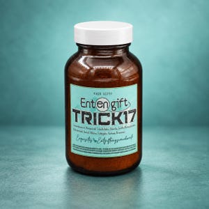 Könnte beinhalten: Eine braune Glasflasche mit weißem Schraubverschluss und hellblauem Etikett. Das Etikett zeigt den schwarzen Schriftzug "Entengift TRICK17" sowie kleingedruckte deutsche Texte zu den Inhaltsstoffen und den Zusatz "Exquisites Entgiftungsräuchwerk."