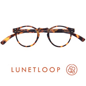 May include: Tortoiseshell glasses with round frames and a keyhole bridge. The inner temple arm features the text LUNETLOOP. Below the glasses, the text LUNETLOOP appears in orange alongside a circular orange logo containing the letters L and O.