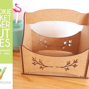 May include: A wooden cookie basket with a cutout design of branches and leaves. The basket has a handle and is made for laser cutting.