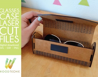 May include: A brown wooden glasses case with a black interior and a geometric pattern on the exterior. The case is open and a pair of sunglasses is inside. The text "GLASSES CASE LASER CUT FILES" is on the left side of the image.
