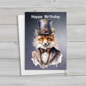 May include: A greeting card featuring a watercolour illustration of a fox wearing a top hat and bow tie. The text "Happy Birthday" is printed on the card.