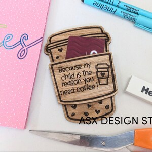 May include: A wooden coffee cup holder with the text "Because my child is the reason you need coffee!"  The holder is designed to hold a gift card or cash. The holder is made of wood and has a brown stain.