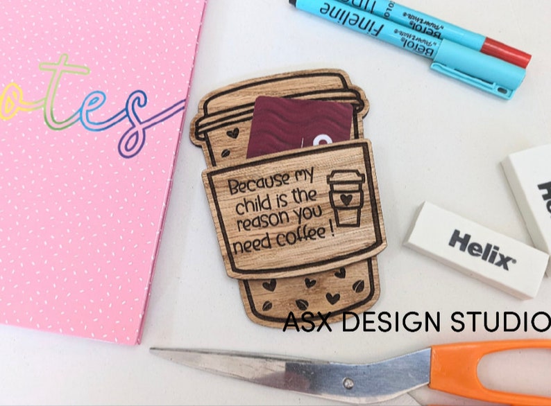 May include: A wooden coffee cup holder with the text "Because my child is the reason you need coffee!"  The holder is designed to hold a gift card or cash. The holder is made of wood and has a brown stain.
