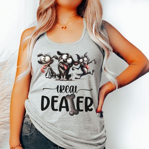 May include: A light gray tank top featuring a playful graphic of three cartoon dogs with their tongues out. Below the dogs, the text reads "Treat Dealer" with a bone graphic. The tank top is sleeveless.