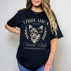 May include: Black t-shirt with a gold graphic of a chihuahua and the text "Chihuahua Social Club Est 2024 Together for the Paws".