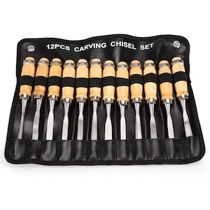 Może przedstawiać: Zestaw 12 dłut do rzeźbienia z drewnianymi uchwytami i metalowymi ostrzami, ułożonych w czarnym etui. Na etui widnieje napis "12PCS CARVING CHISEL SET". Przeznaczone do obróbki drewna i rzeźbienia.