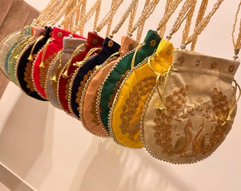 Puede incluir: Una colección de 12 bolsitas redondas bordadas con ribetes de cuentas. Las bolsitas son de varios colores, incluyendo verde, rojo, azul, amarillo y beige. Cada bolsita tiene un cierre de cordón y un borla de cuentas.