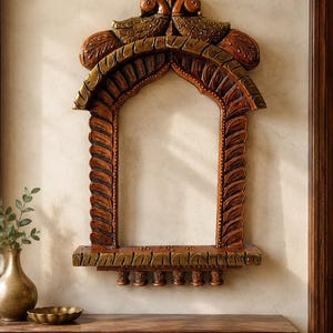 May include: A wall-mounted wooden frame featuring an arched design with carved leaf patterns along the sides. The top is adorned with two carved bird figures facing each other. A small shelf sits at the base with six small hanging pegs underneath.