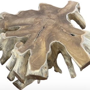 May include: A large, natural wood coffee table with a unique, irregular shape and a rustic, weathered finish. The table top is made from a single piece of wood with a natural grain pattern. The table has a natural, organic look and would be a great addition to any living room or dining room.
