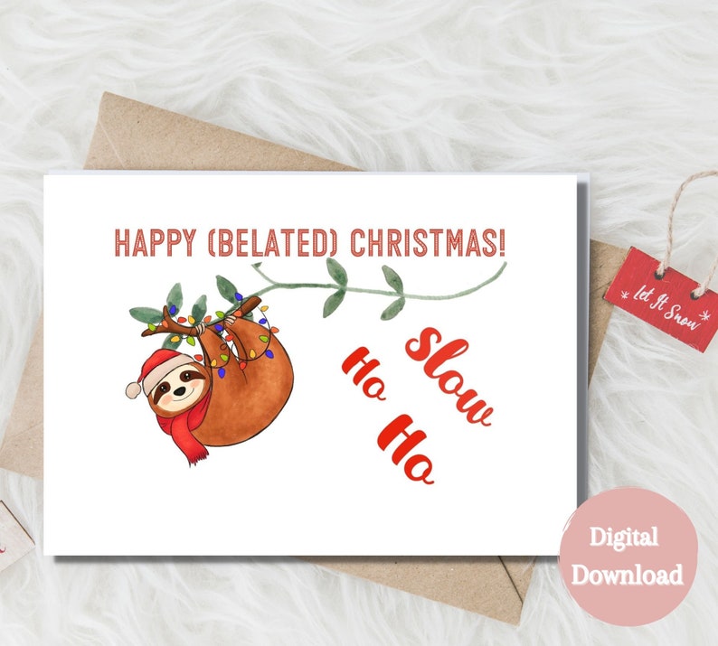 May include: A digital download card featuring a cartoon sloth hanging from a branch with Christmas lights. The text "HAPPY (BELATED) CHRISTMAS!" is at the top of the card. The text "Ho Ho Slow" is written in red below the sloth.