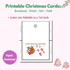 May include: Printable Christmas card featuring a sloth hanging from a branch with Christmas lights. The card is folded in half and has the text "Happy (Belated) Christmas!" and "Ho Ho Slow" on the front. The back of the card is blank.