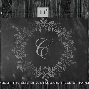 May include: A black slate serving tray with a silver-colored holly wreath design and the letter "C" in the center. The tray is about 8 inches by 11 inches, about the size of a standard piece of paper.
