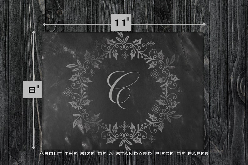 May include: A black slate serving tray with a silver-colored holly wreath design and the letter "C" in the center. The tray is about 8 inches by 11 inches, about the size of a standard piece of paper.