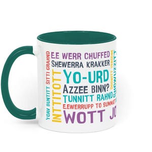 May include: White ceramic mug with a teal interior and handle. The mug features colorful text in various fonts, including the words "YO-URD" and "WOTT JO".
