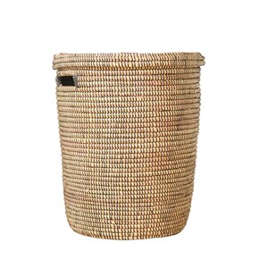 May include: A woven wicker basket with a natural brown and black color. The basket has a round top and a cylindrical shape.
