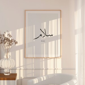 May include: A framed print with the Arabic word for peace, "Salam", written in black calligraphy. The word "Peace" is written in English below the Arabic text.