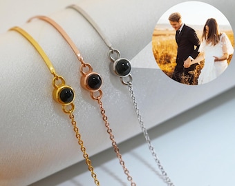 Puede incluir: Tres pulseras de oro, oro rosa y plata con un dije de piedra negra. Cada pulsera tiene una pequeña piedra negra con una imagen oculta en su interior.