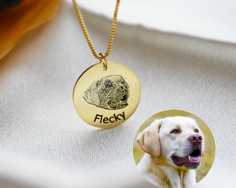 Puede incluir: Un collar con colgante dorado con una imagen grabada detallada de la cara de un perro. El colgante tiene el nombre "Flecky" grabado debajo de la imagen del perro. Una segunda imagen de un perro es visible debajo.