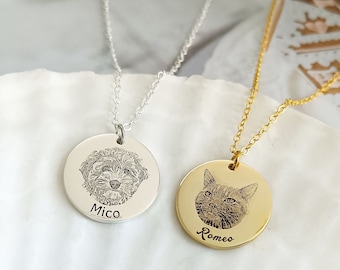 Puede incluir: Dos collares de plata y oro con colgantes redondos que presentan imágenes grabadas de un perro y un gato. El colgante del perro tiene el nombre "Mico" grabado debajo de la imagen, y el colgante del gato tiene el nombre "Romeo" grabado debajo de la imagen.