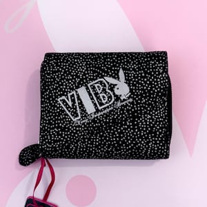 May include: Black wallet with white polka dots and the text "VIB Very Important Bunny" in white. Features a white bunny logo. The wallet has a small loop and a red strap.