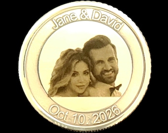 May include: A circular gold-toned metal coin featuring an engraved portrait of two people. The text Jane & David is arched across the top, and the date Oct. 10, 2026 is engraved along the bottom edge. The coin has a smooth, reflective surface.