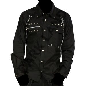 May include: Black button-down shirt with long sleeves, featuring silver chain accents, a zippered chest pocket, and studded details. The shirt has a classic collar and is made of a dark, possibly cotton, material. The shirt is from Darkland.