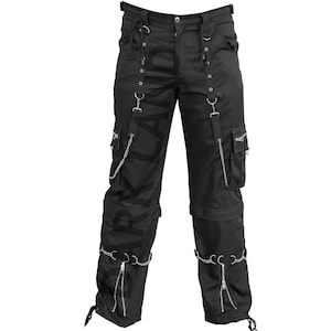 May include: Black cargo pants with multiple straps and chains. The pants have a zipper detail on the legs and a large pocket on each side.