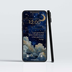 May include: Black smartphone featuring a night sky wallpaper with clouds, stars, and a crescent moon. The screen shows the time and the text: "I am grateful that I understand what matters to me."