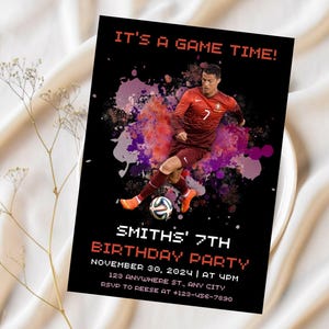 May include: A black and red birthday party invitation with a soccer player in a red and white jersey. The invitation says "It's a game time!" and "Smith's 7th Birthday Party". The invitation includes the date, time, location, and RSVP information.