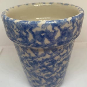 May include: A small, blue and white ceramic planter with a speckled glaze.