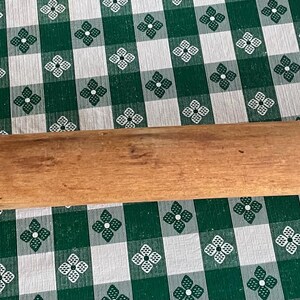 May include: A wooden rolling pin with a light brown color and a smooth surface.