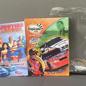 Puede incluir: Colección de recuerdos que incluye un cómic de Justice League Adventures, un programa de recuerdo de Tropicana 400 y una bolsa de plástico transparente con el logotipo de Tropicana. El cómic presenta superhéroes de DC. El programa muestra coches de carreras.