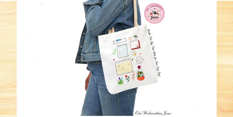 Puede incluir: Un bolso tote blanco con asa color crema, con garabatos bordados de un calendario, notas y flores. La bolsa tiene el texto "Doodle Tote Bag That Made for Your Cozy Days" y "On Wednesday June". Tambi&eacute;n es visible un logotipo rosa con la palabra "June".
