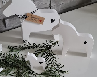 May include: Three white wooden horses with black hearts painted on them. The largest horse has a brown tag that says "Handmade with Love".