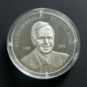 May include: Silver commemorative coin featuring a portrait of George H.W. Bush, the 41st U.S. President, with the text "XLI U.S. PRESIDENT GEORGE BUSH" and the years "1989" and "1993" around the portrait. The coin also has the text "$20" at the bottom.