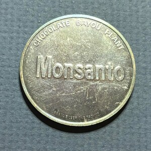 May include: A silver coin with the words "Chocolate Bayou Plant" and "Monsanto" inscribed around the edge. The coin also reads "99.9% Silver One Troy oz."