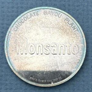 May include: A silver coin with the words "Chocolate Bayou Plant Monsanto" and "999 1/2 Silver One Troy Oz." inscribed on it.