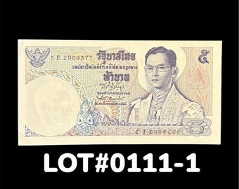 May include: A Thai 5 baht banknote featuring a portrait of King Bhumibol Adulyadej wearing glasses and formal attire. The bill includes intricate patterns, Thai script, the serial number 5 E 2009577, and the text LOT#0111-1 printed below it.