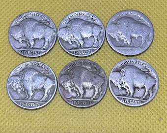 May include: Six silver US five-cent coins featuring the profile of a buffalo with the words "United States of America" and "Five Cents" inscribed on each coin.