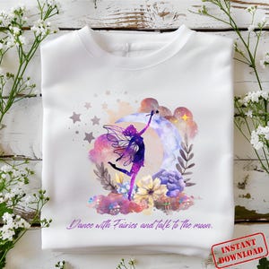 Könnte beinhalten: Ein weißes T-Shirt mit einer lila Fee, die auf einem Halbmond mit Sternen und Blumen tanzt. Der Text "Dance with fairies and talk to the moon." ist auf das T-Shirt gedruckt.