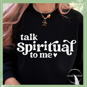 May include: Black sweatshirt with white text that reads "talk spiritual to me" with a heart symbol. The text has a distressed, vintage look.