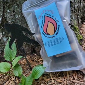 May include: A clear plastic bag containing a package of wood chips for smoking meat. The package is labeled "Chef Fredz Bourbon 1yr Scott. Ale Finished Double Barrel Aged Oak".