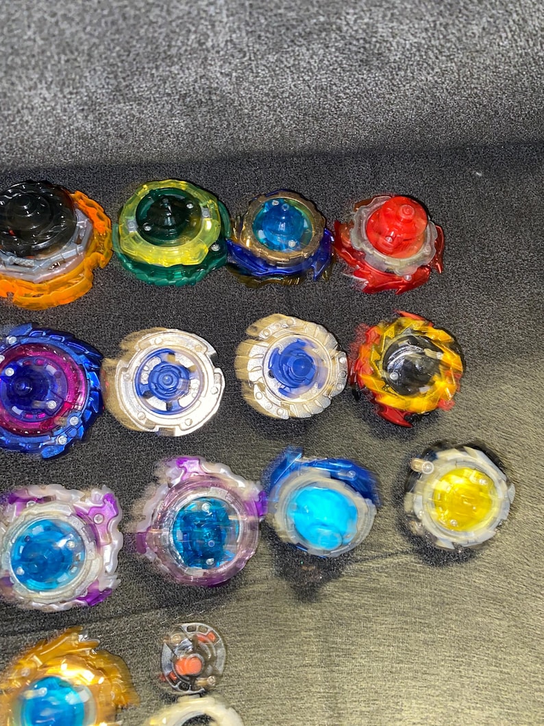 Puede incluir: Una colecci&oacute;n de peonzas coloridas en varios dise&ntilde;os. Las peonzas presentan una mezcla de colores, incluyendo rojo, azul, amarillo, verde y morado. Cada peonza tiene un dise&ntilde;o &uacute;nico con m&uacute;ltiples capas y texturas.