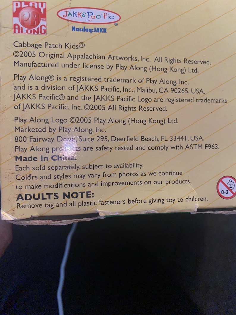 Pu&ograve; includere: Una scatola di cartone color marrone chiaro con i loghi Play Along e JAKKS Pacific. Il testo include Cabbage Patch Kids, copyright 2005, dettagli di produzione e una nota per gli adulti di rimuovere le chiusure in plastica prima dell'uso.