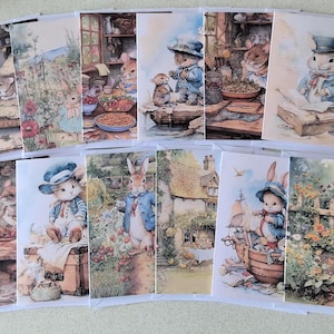 May include: A set of greeting cards with watercolour illustrations of animal characters in charming scenes. The cards show rabbits and mice in settings like gardens and kitchens. The artwork has a vintage, storybook style, reminiscent of classic children's literature.